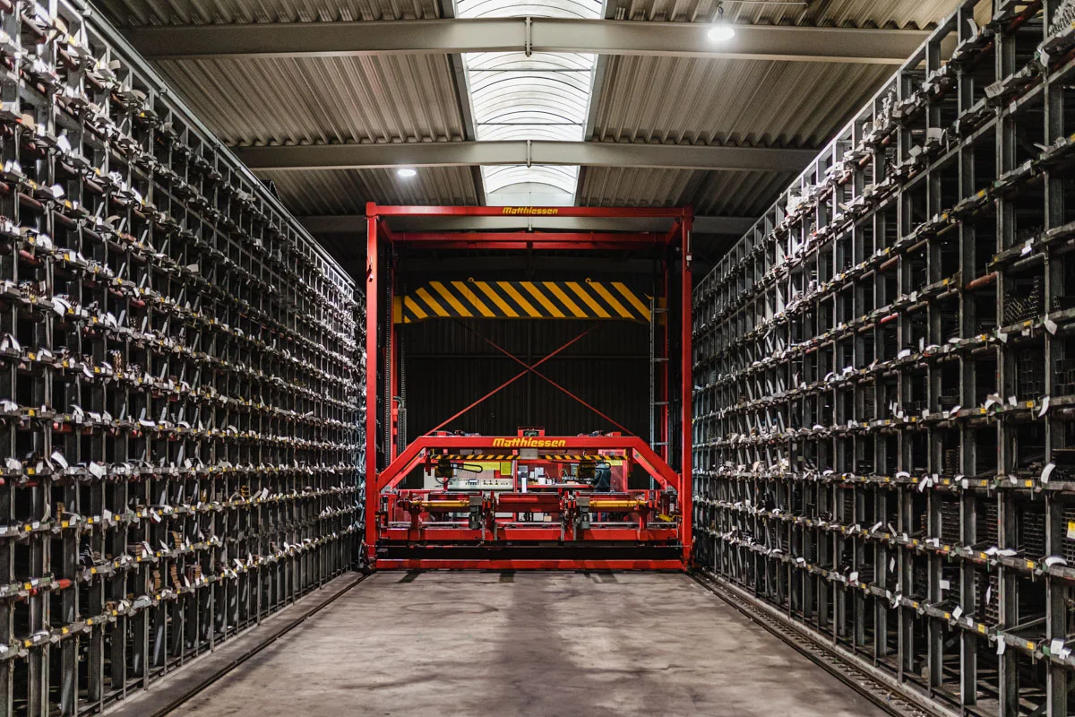Hochregallager mit Wabenregalen und roter Krananlage im Stahl-Logistik-Center